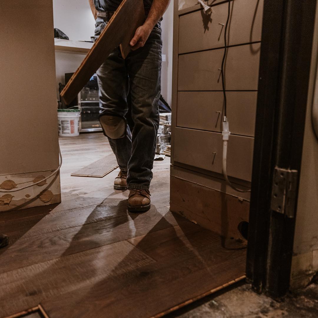 Installer carrying wood plank